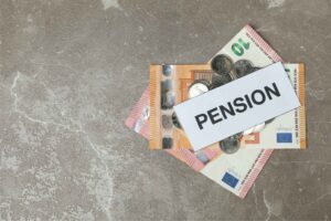Geldscheine mit dem Schild „PENSION“ als Symbolbild für gesetzliche Rente in Deutschland