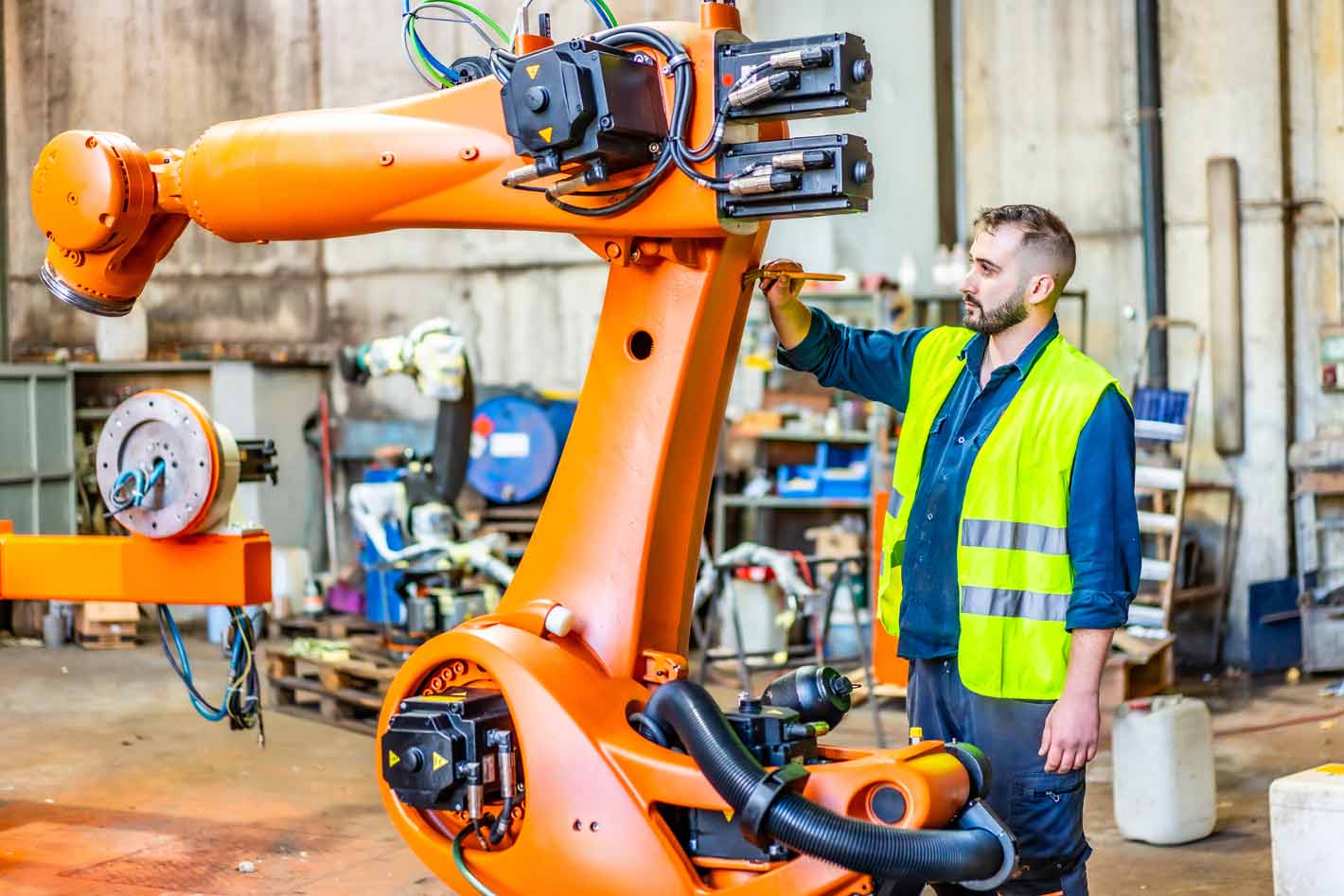 ki-in-der-industrie-robitik-maschinen Ki ersetzt jobs: Mensch erhebt die faust gegen eine Roboter-faust – Symbolbild dafür, dass die künstliche intelligenz in konkurrenz mit angestellten steht