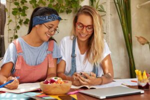 Freundinnen testen Sprachlern-Apps beim gemeinsamen Frühstück