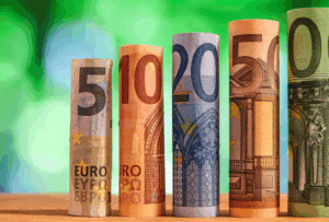 Gerollte Euro-Banknoten verschiedener Werte auf grünem Hintergrund - wie funktioniert der Euro