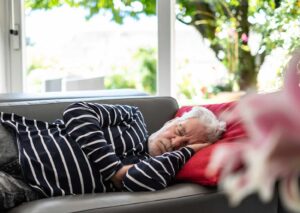 Älterer Mann beim Mittagsschlaf auf dem Sofa – typische Veränderung im Schlafrhythmus im Alter