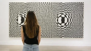 Besucherin betrachtet ein großes Op-Art-Wandbild, Beispiel für optische Täuschungen